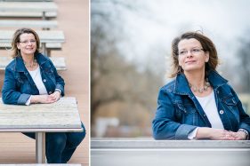 Geschäftsfrau sitzt an einem Holztisch im Freien, Businessfoto.